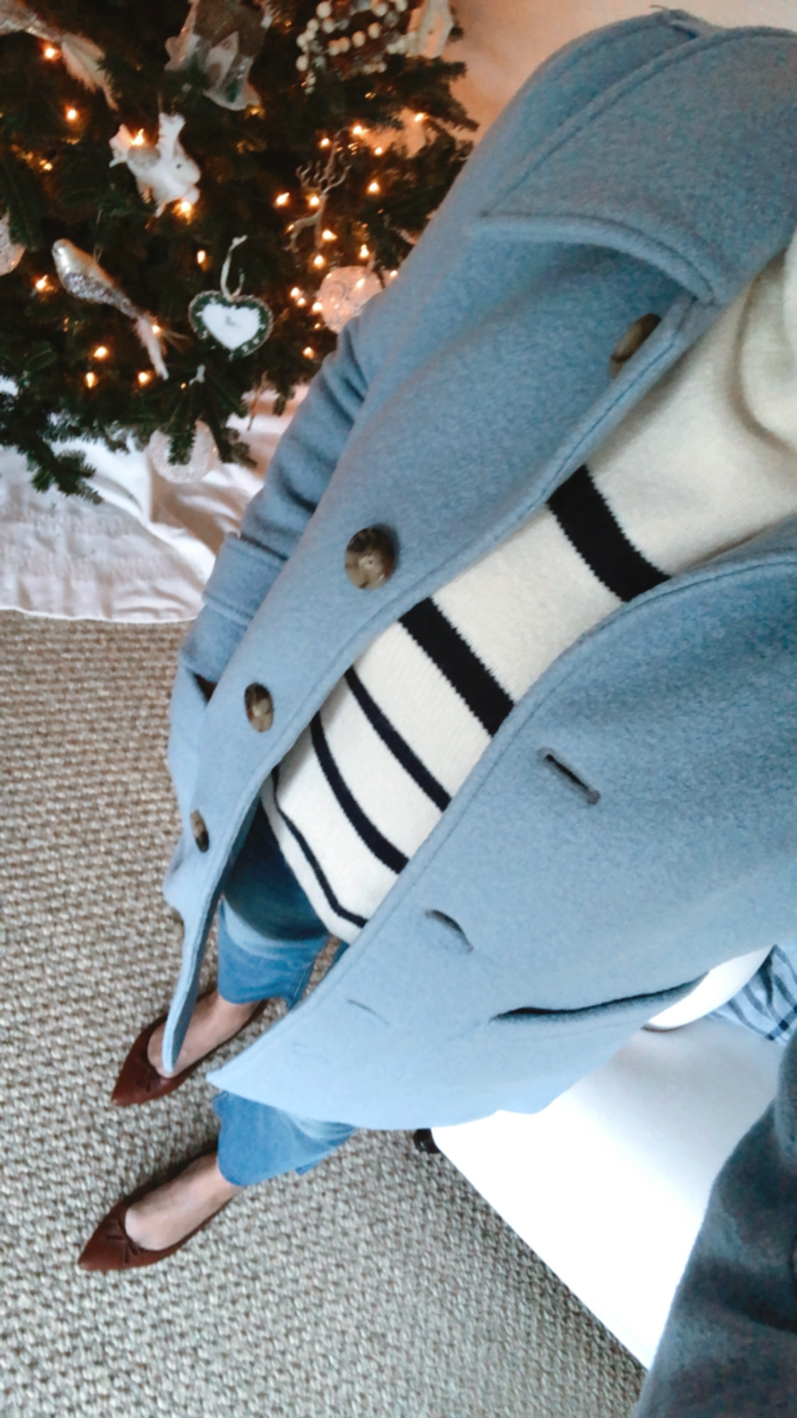 Desiree Leone wearing Holiday Outfit Ideas wearing Striped mock neck sweater, cozy blue lady coat, jeans, and ballet flats